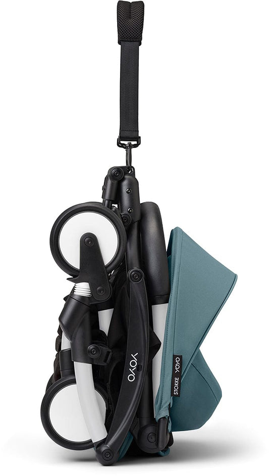 White and aqua ultra-compact stroller by Stokke, featuring quilted seat, black accents, and four wheels, shown in side view.