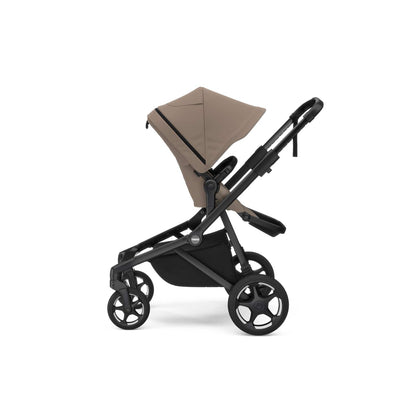 Thule beige stroller with black frame and wheels viewed from the side