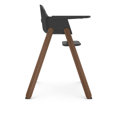 Side view of UPPAbaby high chair with dark grey seat and wooden legs