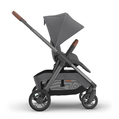 Side view of UPPAbaby stroller with grey fabric and brown leather handle