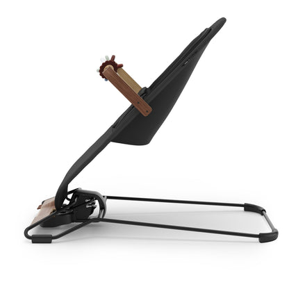 Side view of a black baby bouncer with a wooden toy bar on a white background