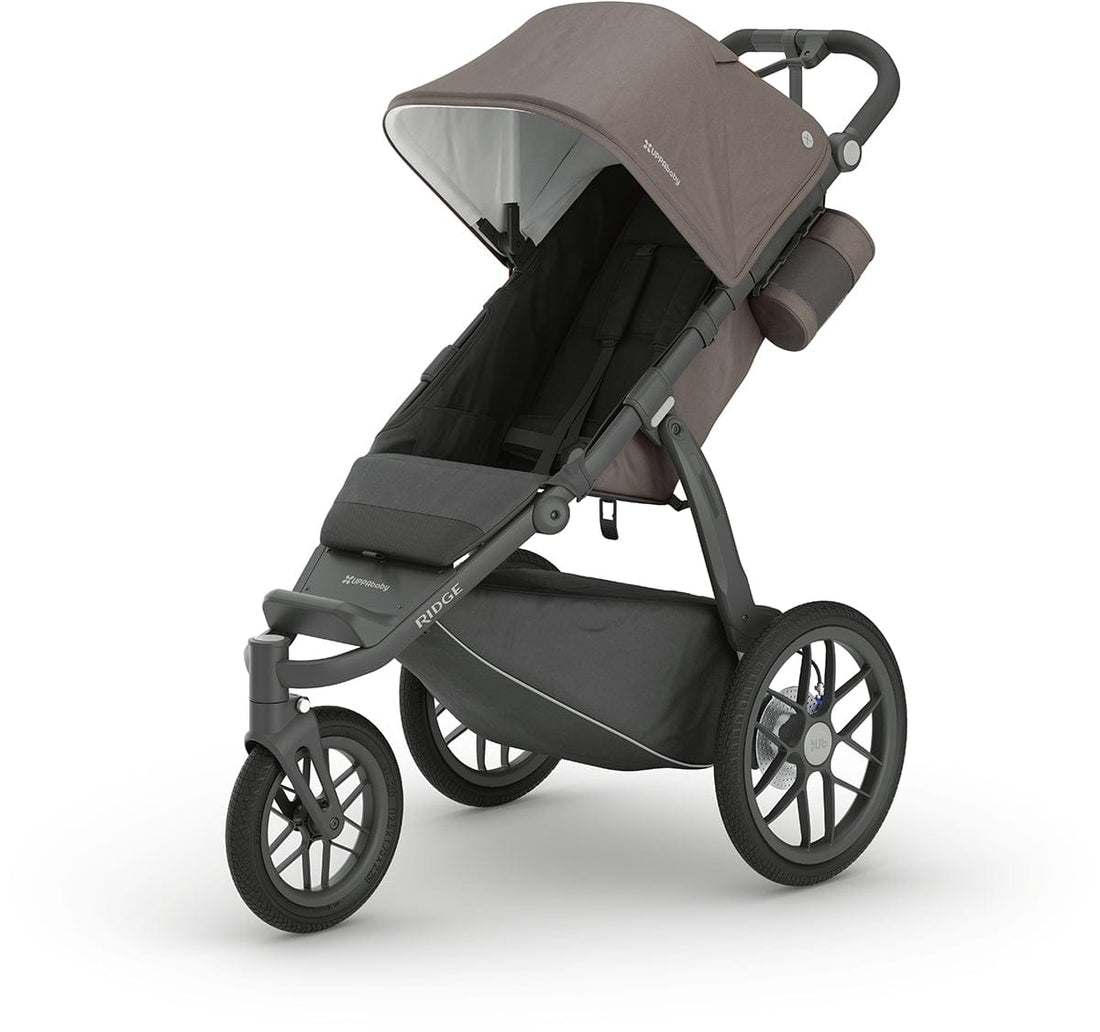 Dark taupe and carbon Ridge jogging stroller by UPPAbaby, featuring large air-filled wheels, adjustable canopy, and side view angle
