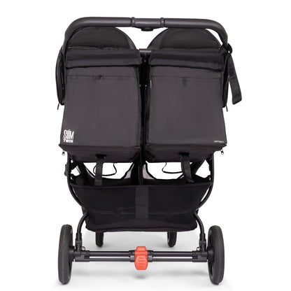 Rear view of black Valco Slim Twin Series 2 double stroller with storage basket and red brake pedal