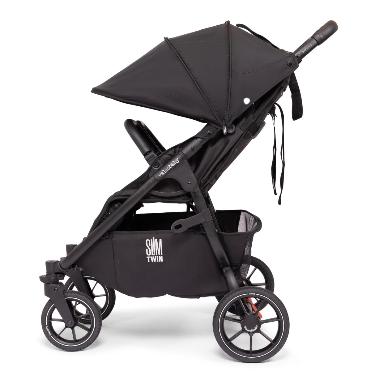 Side profile of a black Valco Baby Slim Twin stroller with canopy and storage basket