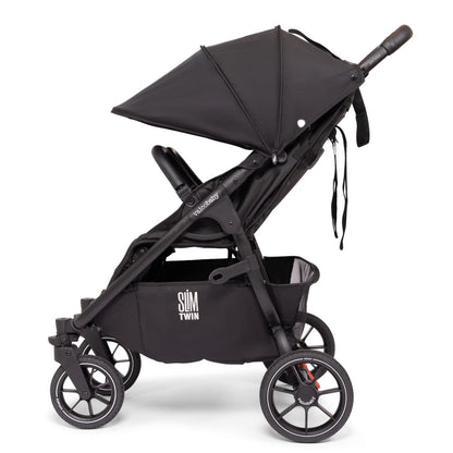 Side profile of a black Valco Baby Slim Twin stroller with canopy and storage basket