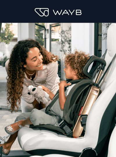 A child sits in a car seat while a woman holding a toy looks at them. "WAYB" logo at the top.